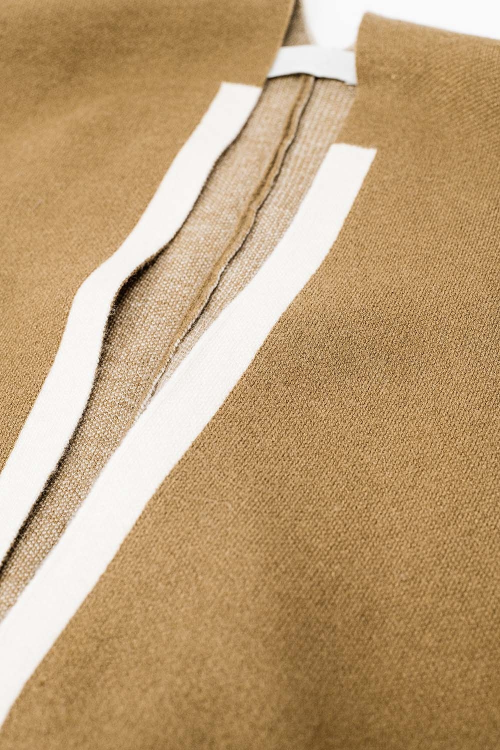 Poncho de punto en camel con ribete crudo Poncho de punto en camel con ribete crudo