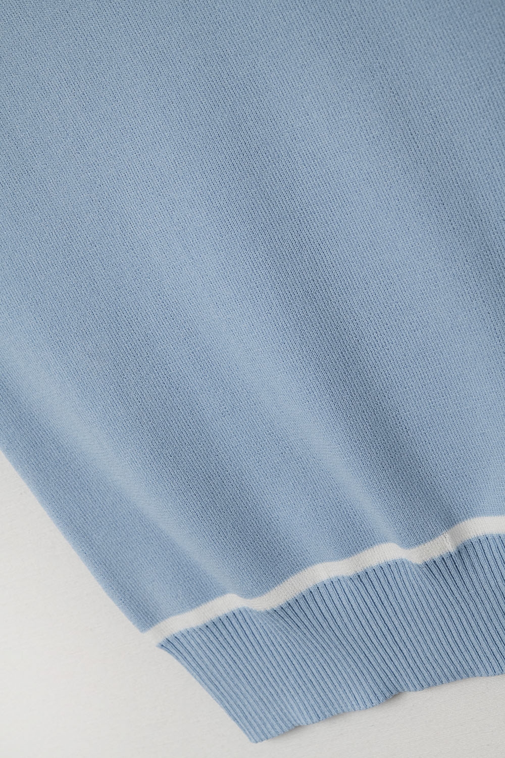 Suéter sin mangas en azul con detalle de líneas blancas Suéter sin mangas en azul con detalle de líneas blancas