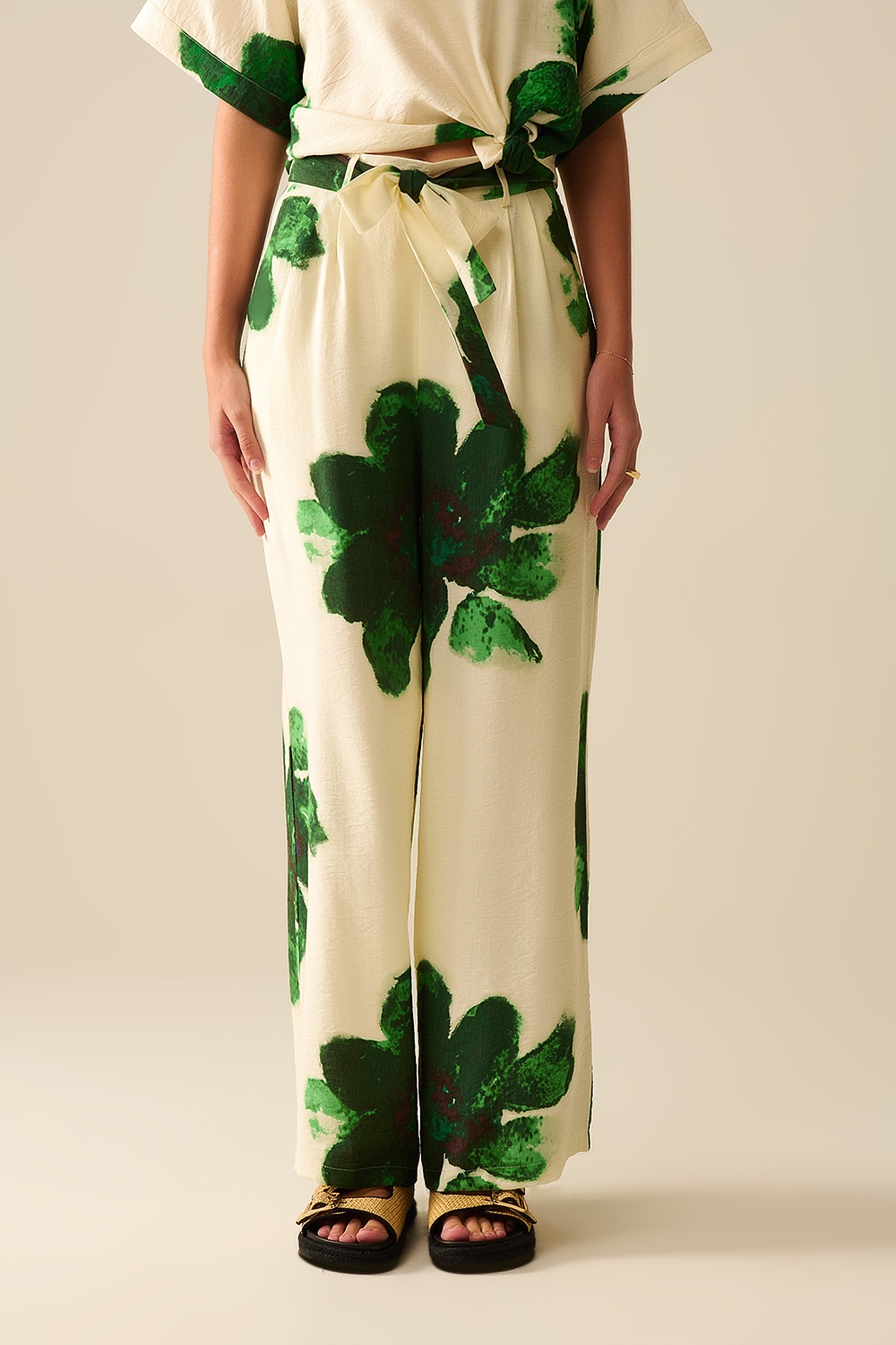 Pantalones Palazzo blancos con estampado de flores tropicales verdes y cinturón a juego Pantalones Palazzo blancos con estampado de flores tropicales verdes y cinturón a juego