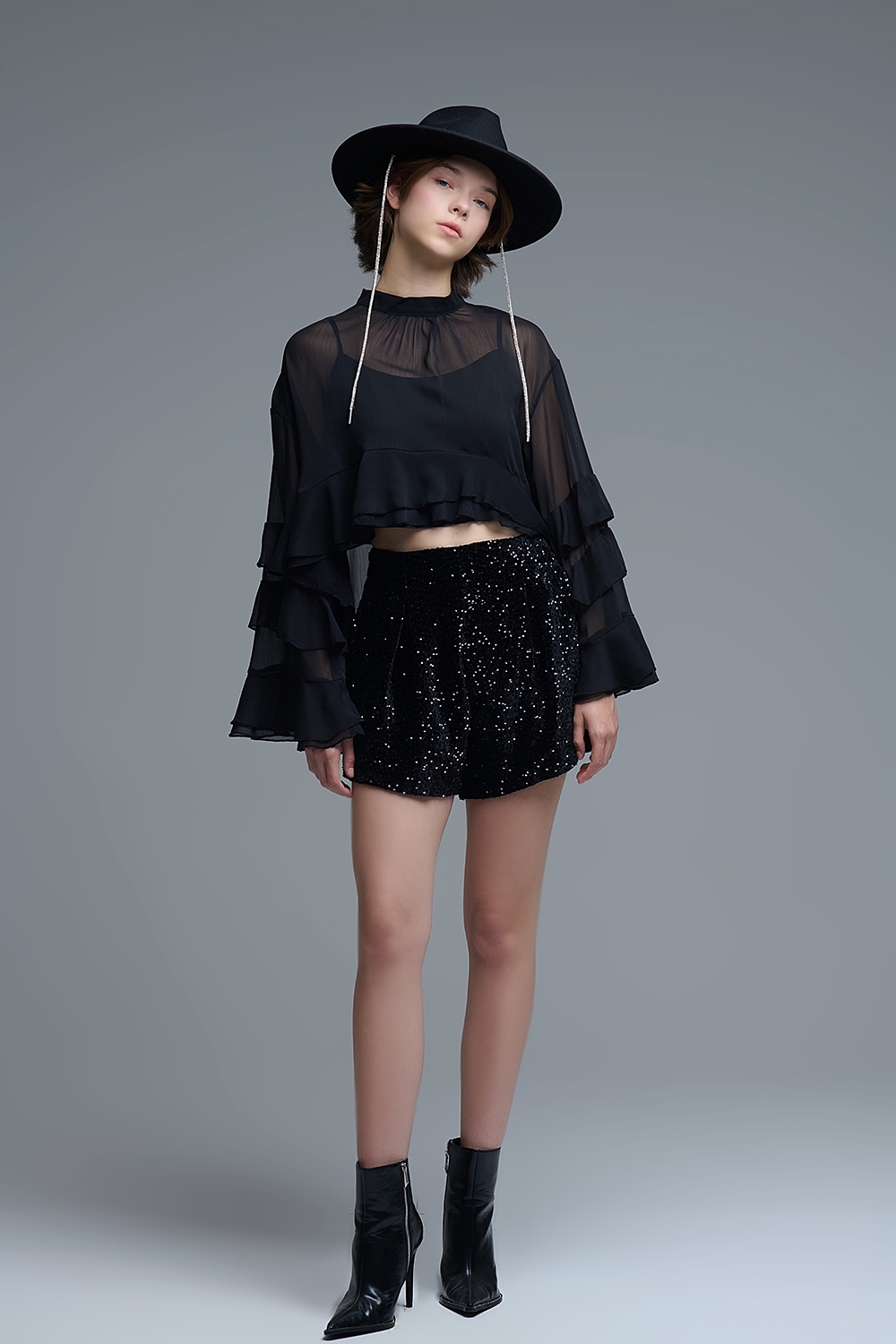 Blusa negra de gasa con volantes y transparencias estilo capa