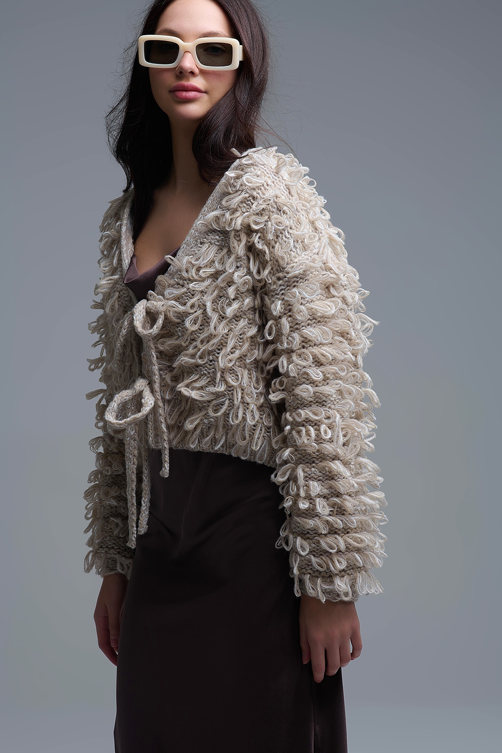 Chaqueta de punto grueso beige con cuello en V y cierre de lazo delantero