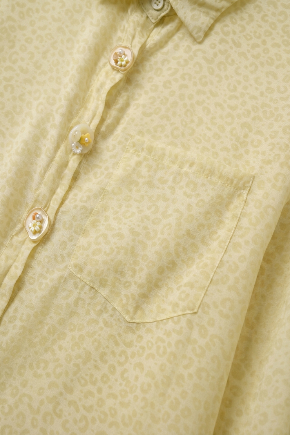 Blusa de transparencias con botones en amarillo claro y sutil estampado