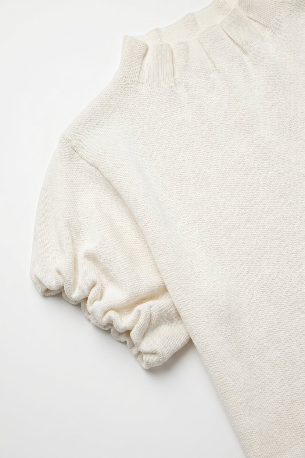 Su&eacute;ter de punto fino color crema con cuello simulado mangas cortas y pliegues