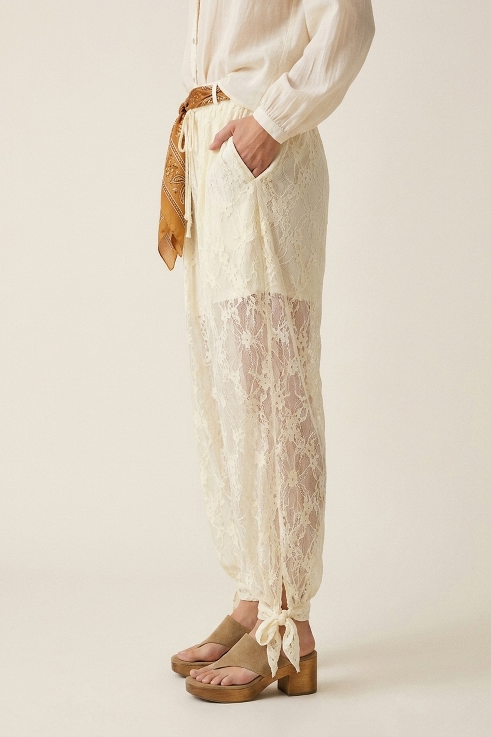 Pantalones de corte relajado con encaje floral color crema y bajo con lazo