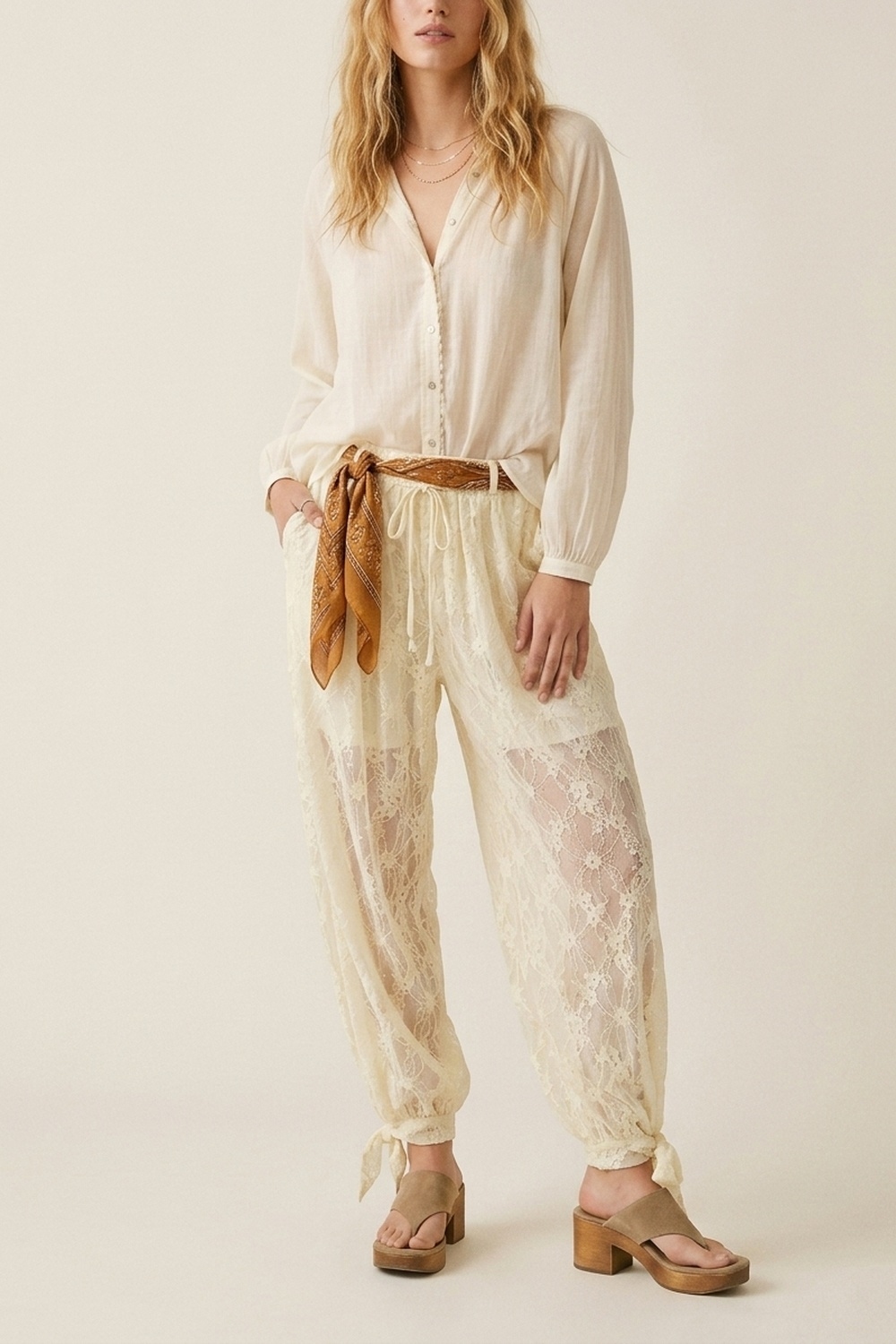 Pantalones de corte relajado con encaje floral color crema y bajo con lazo