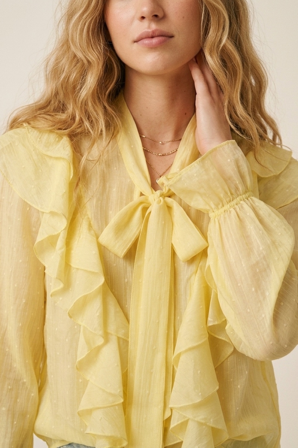 Blusa amarilla con volantes y lazo en el cuello