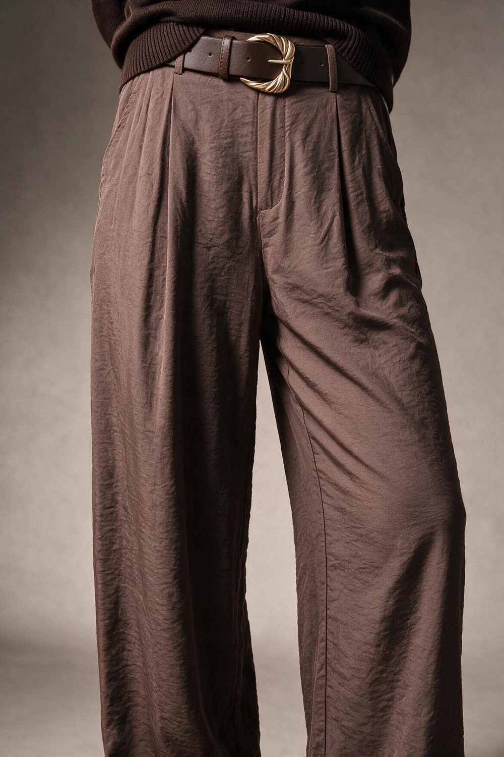 Pantalones anchos con textura marrón brillante con cinturón y detalle de pliegues Pantalones anchos con textura marrón brillante con cinturón y detalle de pliegues