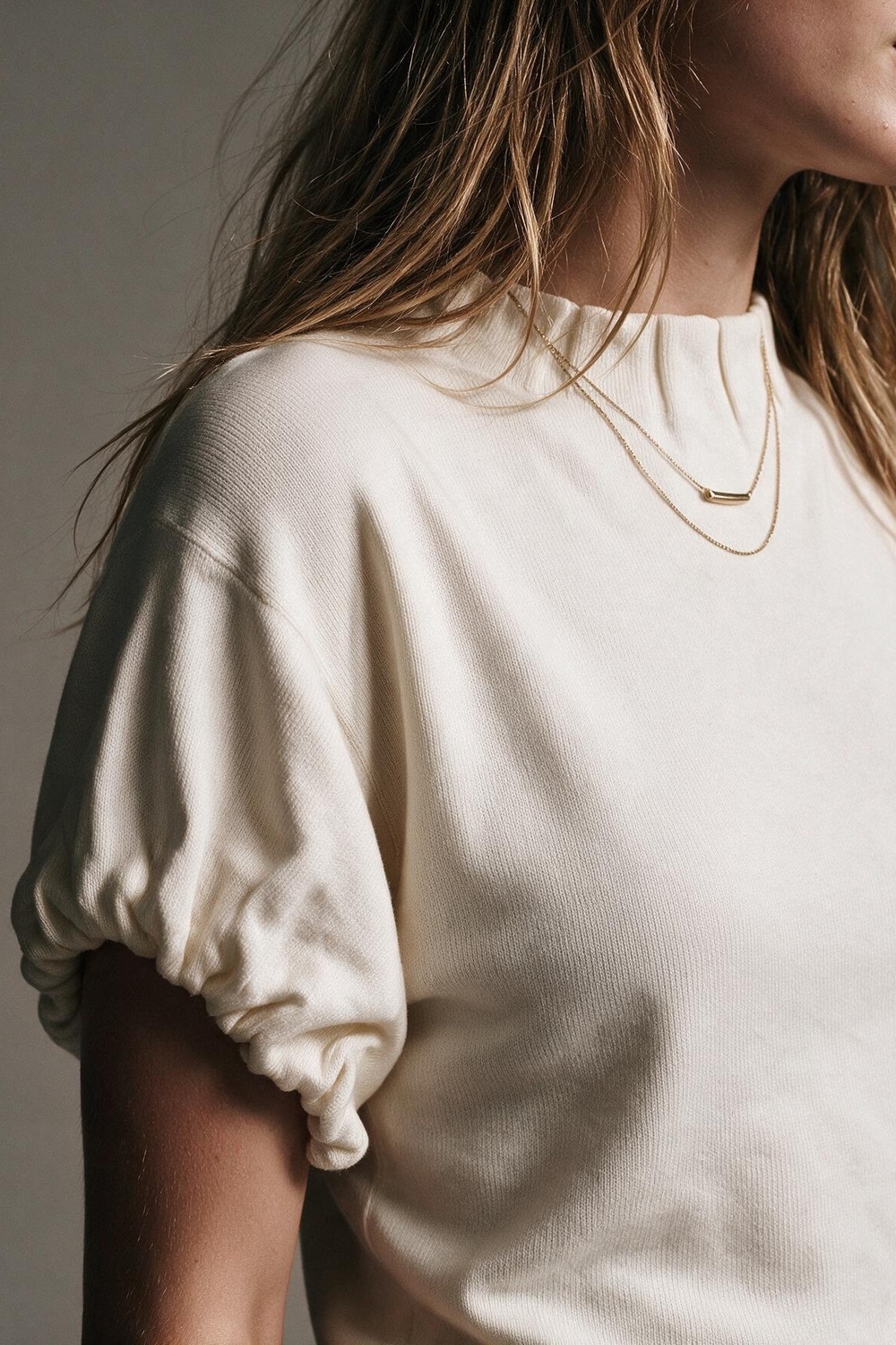 Su&eacute;ter de punto fino color crema con cuello simulado mangas cortas y pliegues