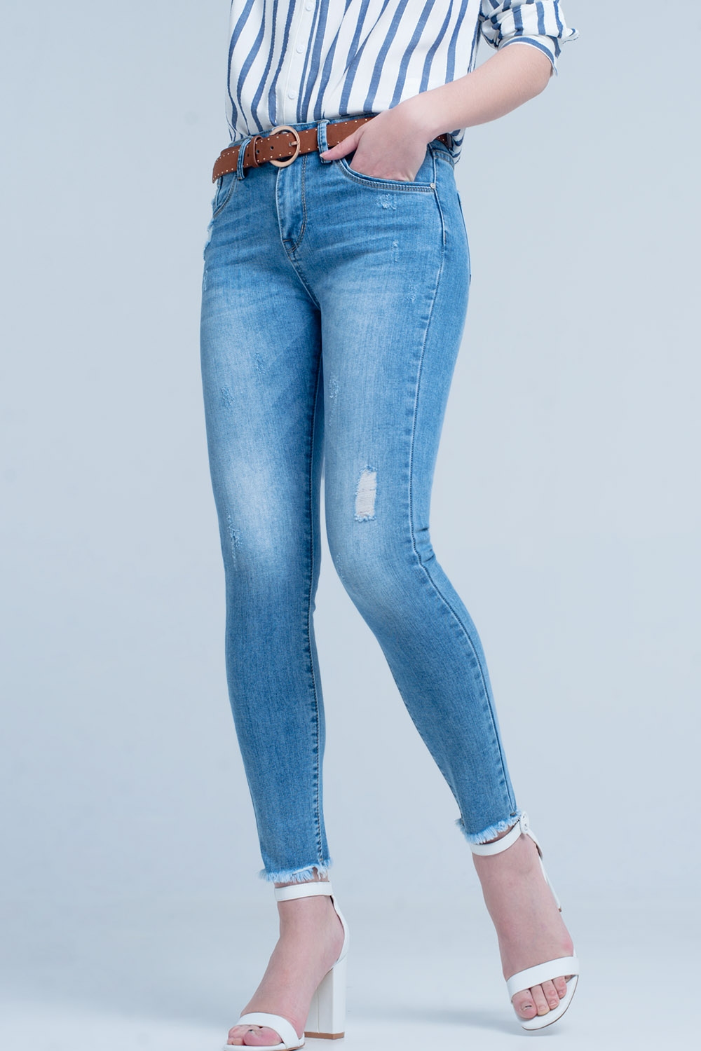 Vaqueros ajustados en azul con detalle rasgado