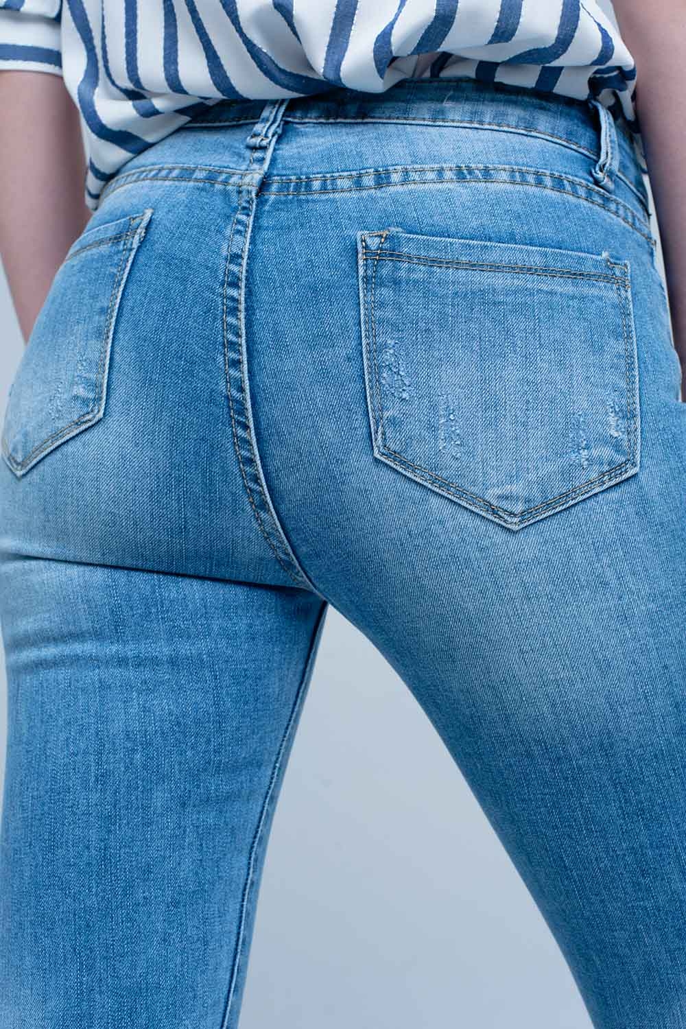 Vaqueros ajustados en azul con detalle rasgado