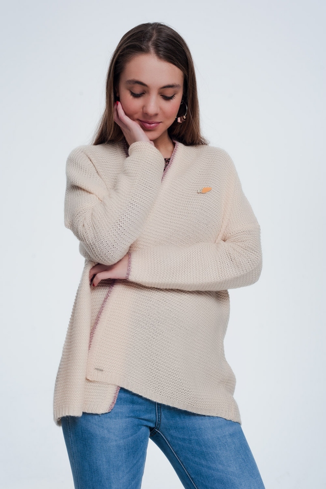 Roze cardigan met glimmende details en een pin