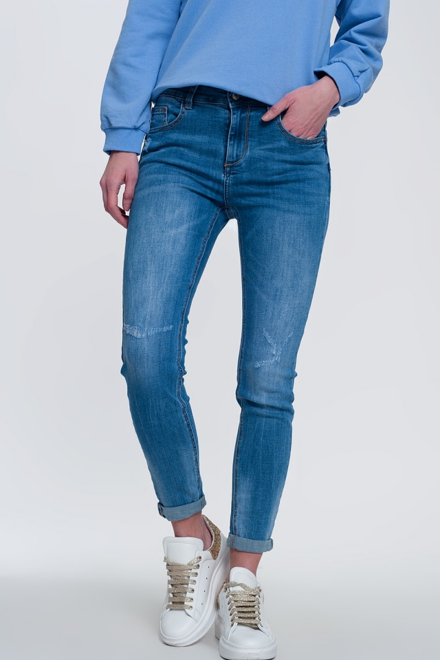 Licht denim skinny jeans met gevouwen enkels en slijtage detail