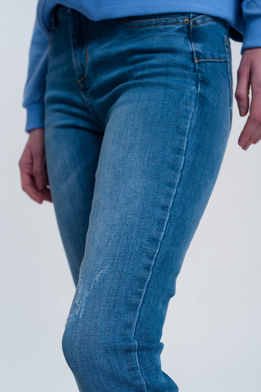 jeans ajustados de mezclilla clara con tobillos doblados y detalle rasgado jeans ajustados de mezclilla clara con tobillos doblados y detalle rasgado