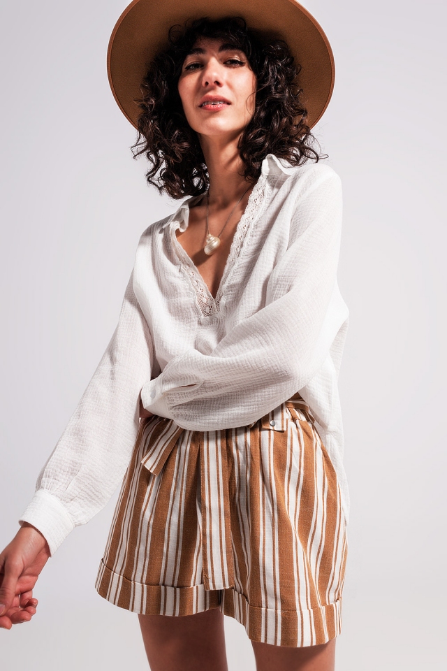 Blusa color crema con cuello de pico y detalle de encaje