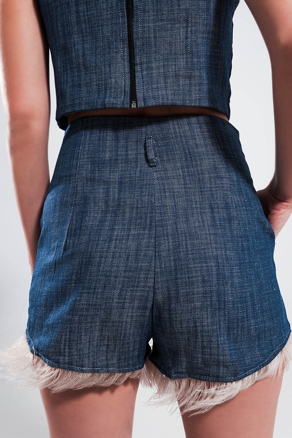 Pantalones cortos de traje color azul con plumas sint&eacute;ticas en el bajo