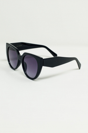 Gafas de sol estilo ojo de gato extragrandes con ribete ancho en negro.