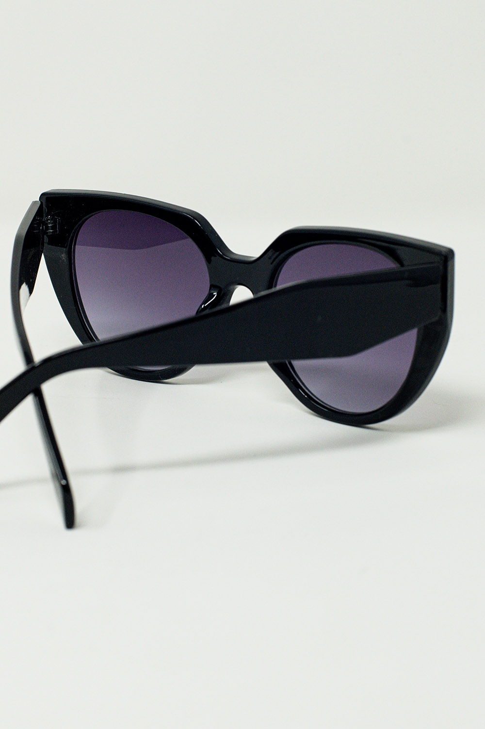 Gafas de sol estilo ojo de gato extragrandes con ribete ancho en negro.