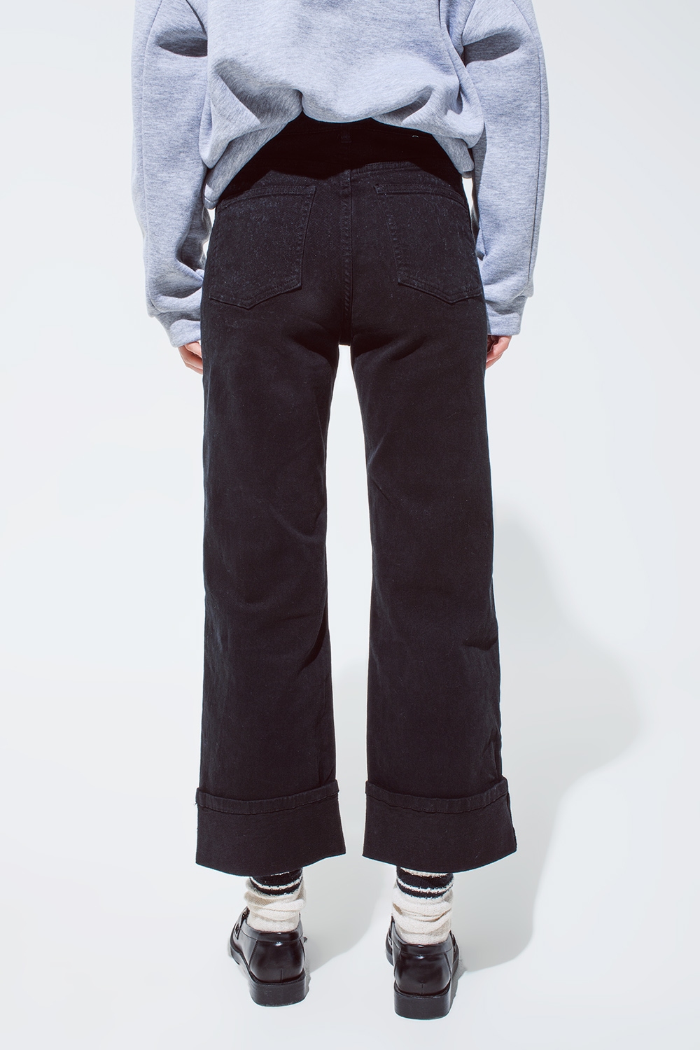 Pantalones vaqueros rectos en negro con perneras dobladas