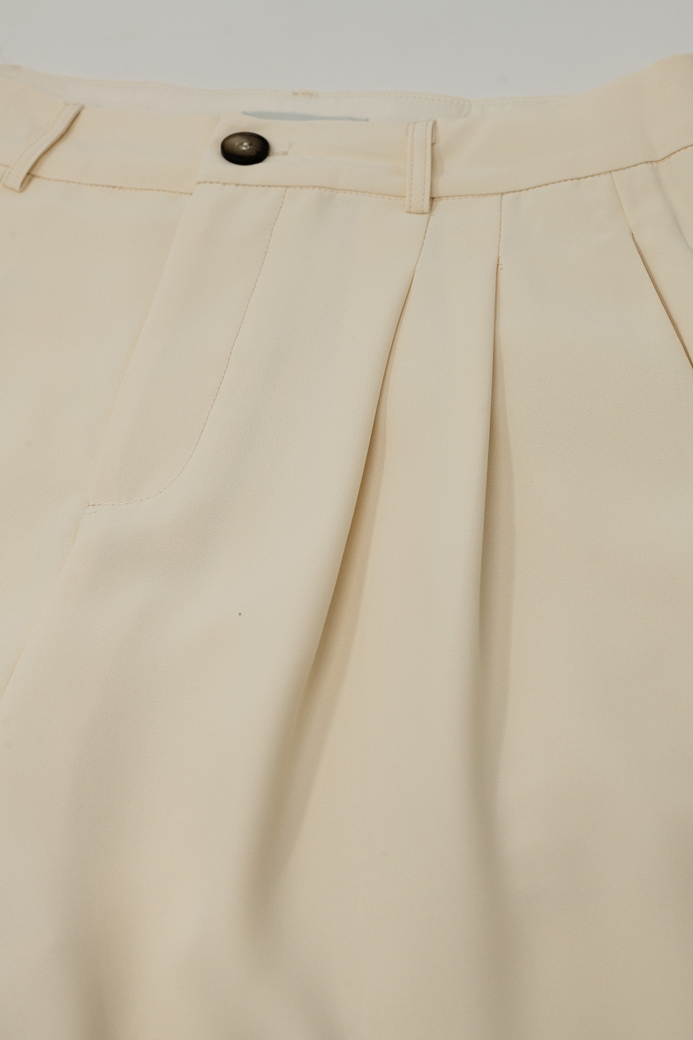 Pantalón recto con bolsillos laterales y pinzas en color crema Pantalón recto con bolsillos laterales y pinzas en color crema