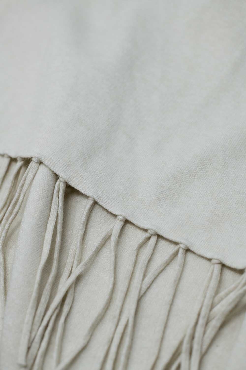 Suave poncho de punto beige con flecos