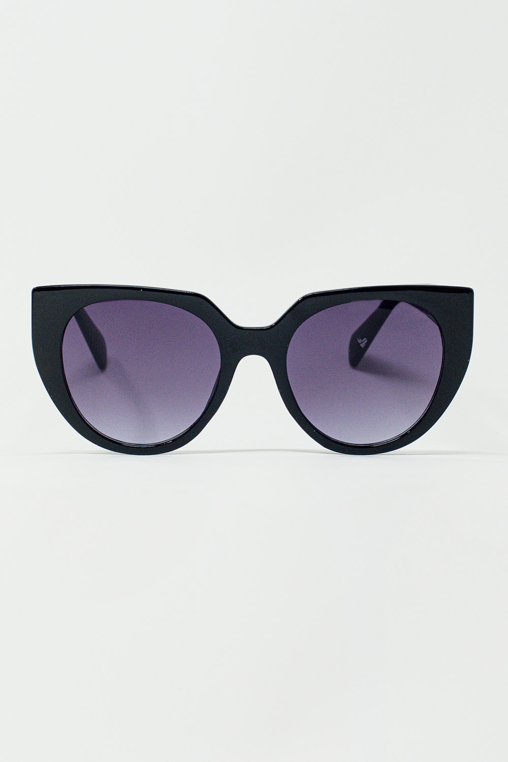 Gafas de sol estilo ojo de gato extragrandes con ribete ancho en negro.